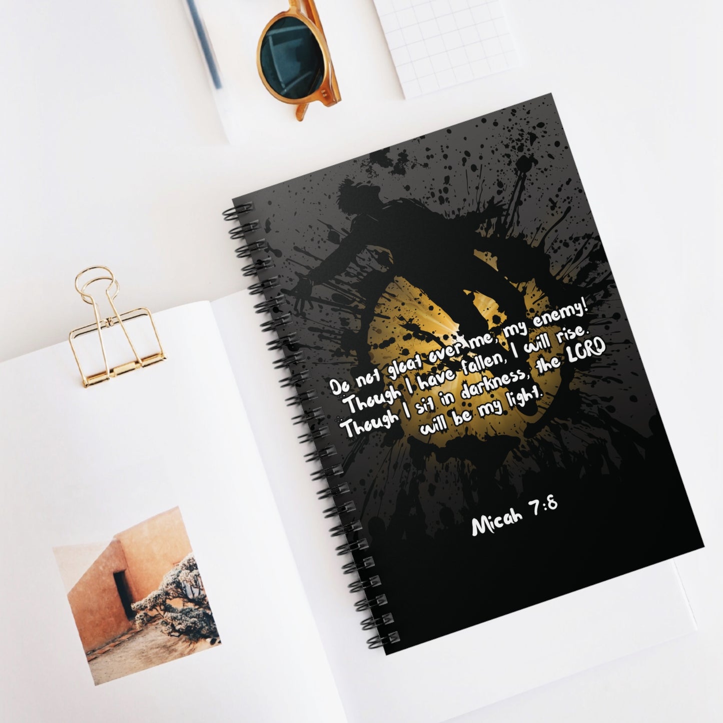 The "Don't Gloat over me" Spiral Christian Journal displayed on a white desk top beside several pencils, papers and clips—perfect for Bible study, journaling, or devotional time.