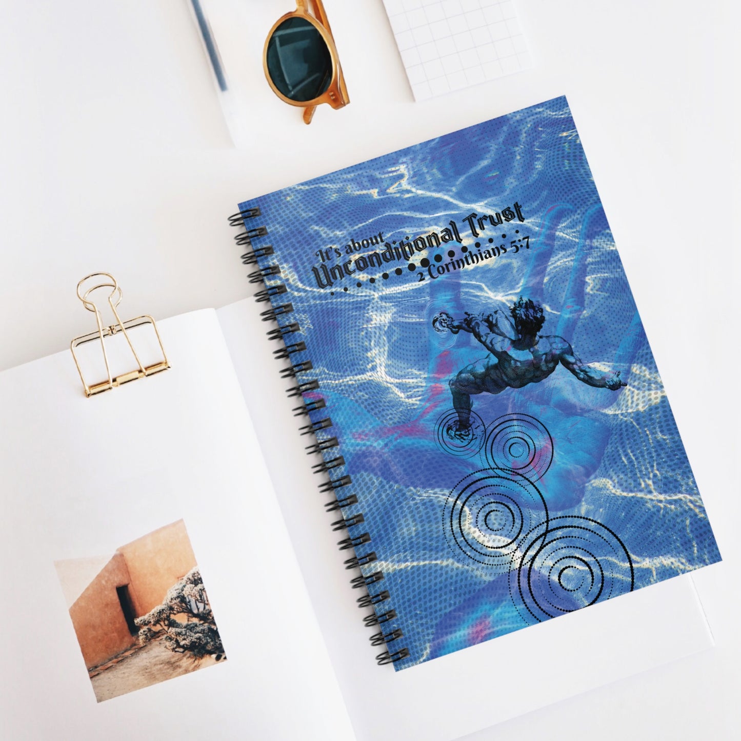 The Unconditional Trust Spiral Christian Journal displayed on a white desk top beside several pencils, papers and clips—perfect for Bible study, journaling, or devotional time.