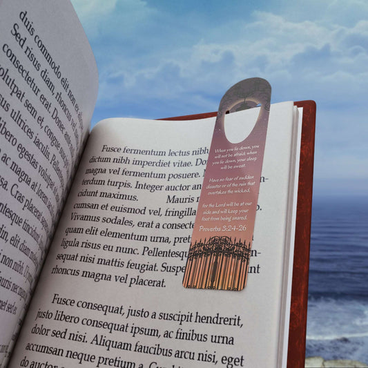 'When I lie down, I will not be afraid' -Proverbs 3:24-26 Christian Bookmark Front view in use on example book page on the beach.