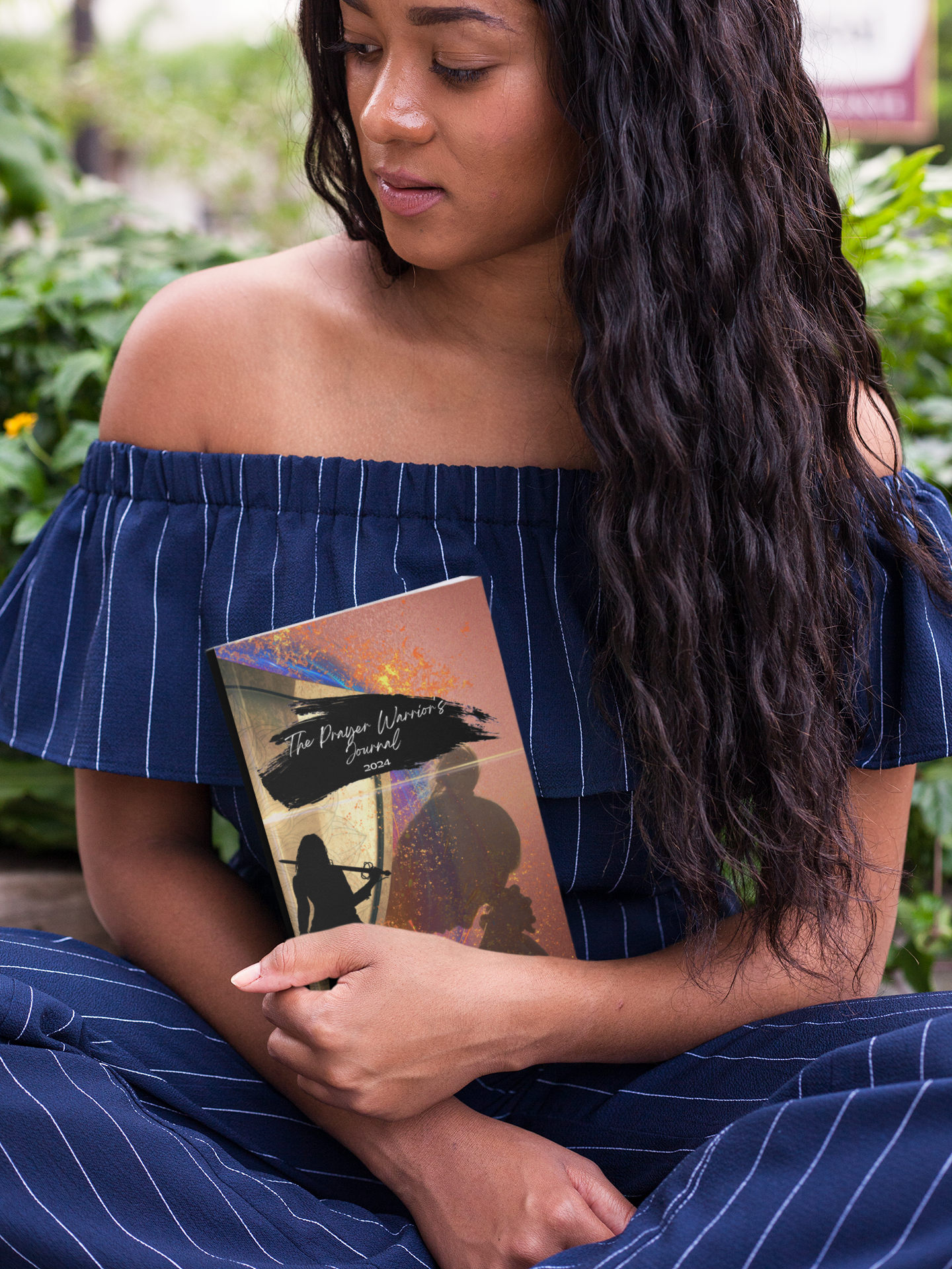 Young woman holding the prayer warrior's journal for women at the park